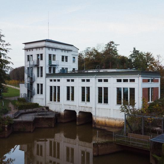 Billedet viser Karlsgårdeværket set fra vandsiden ved solnedgang