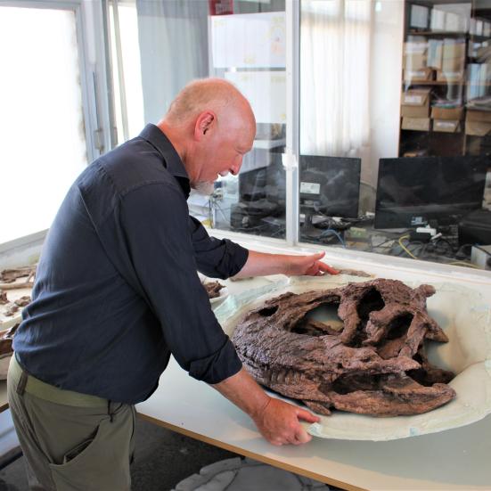 Billedet viser Steen Sigurd Andersen i et laboratorium med dele fra en dinosaur