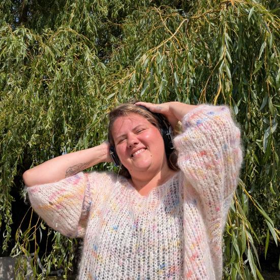 Billedet viser en smilende Kathrine Levald, der groover foran et træ