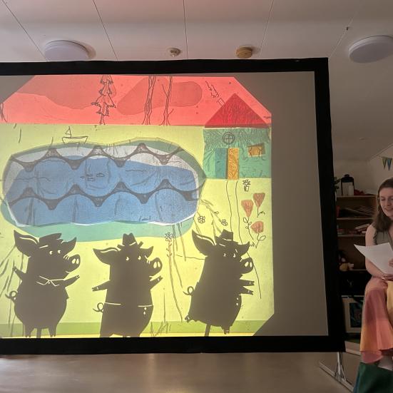 Biblioteksformidler fortæller ved teaterskærm