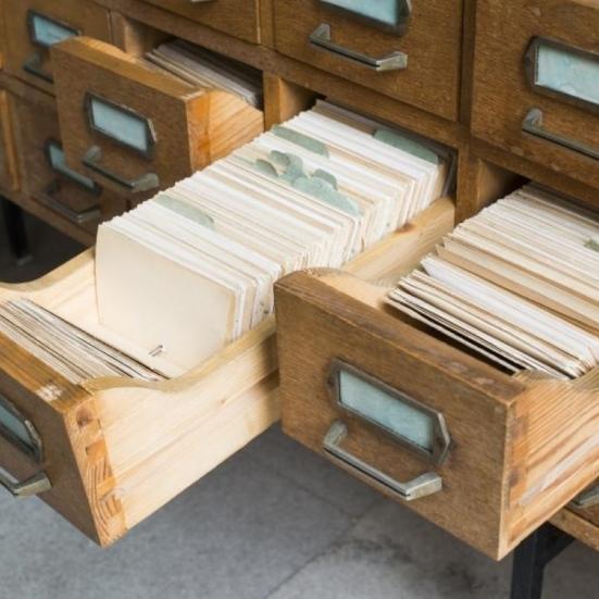 Billedet viser en række gamle arkivskuffer, hvoraf to er åbne