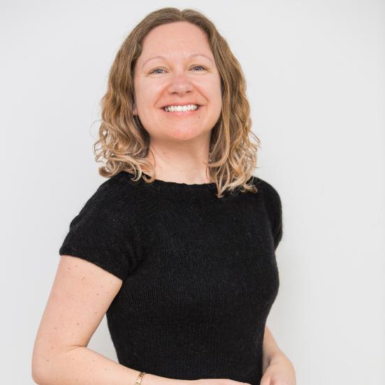 Fotoet viser en smilende Jane Ibsen Piper i en sort T-shirt foran en hvid væg