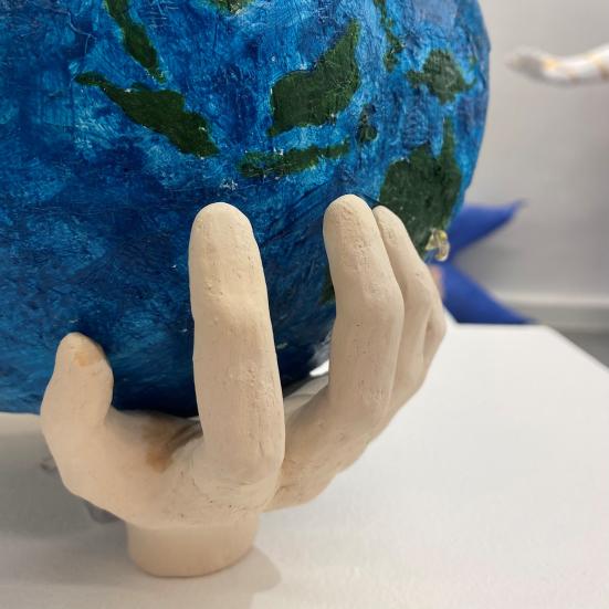 Kunst fra Børnenes Udstilling som forestiller en hånd, der holder Jorden