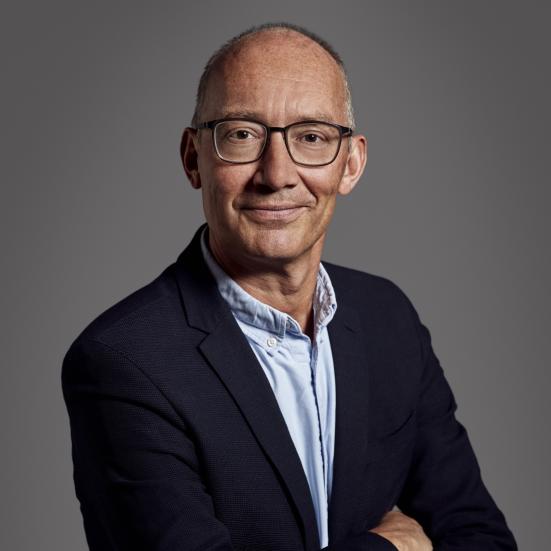 Fotoet viser Niels Krause-Kjær med armene over kors og et venligt smil rettet mod beskueren