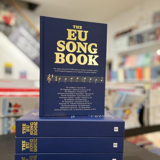 Fotoet viser en stak EU Song Books. Den øverste har forsiden vendt fremad