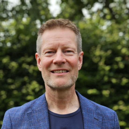 Billedet er et foto af en smilende Claus Thornby Larsen iført blåt tøj med EU-stjerner