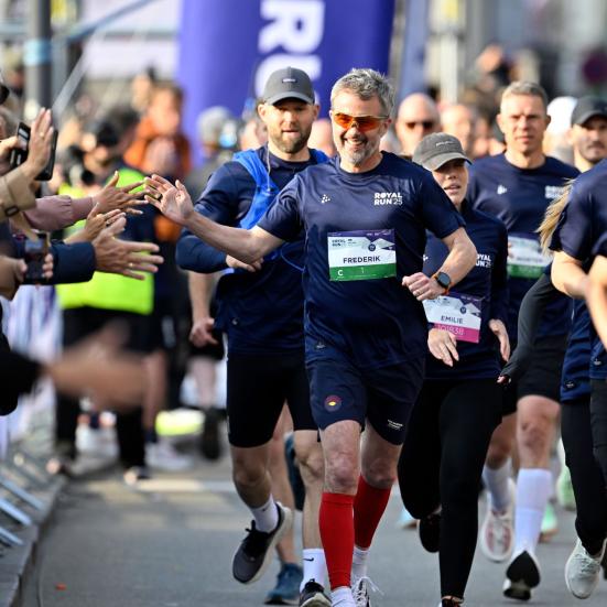 Kong Frederik løber Royal Run og giver highfives til publikum langs ruten.