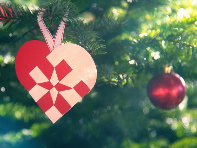 Billedet viser et flettet julehjerte på et juletræ