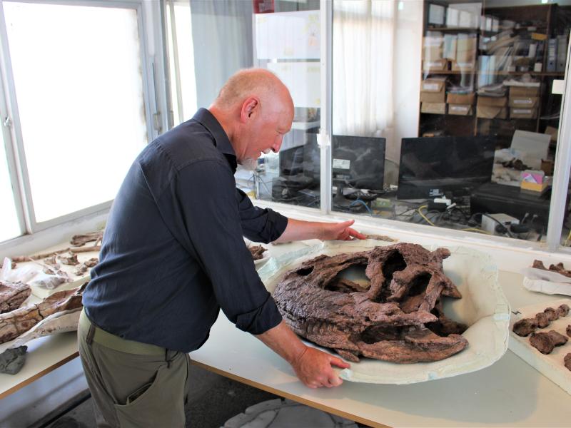 Billedet viser Steen Sigurd Andersen i et laboratorium med dele fra en dinosaur