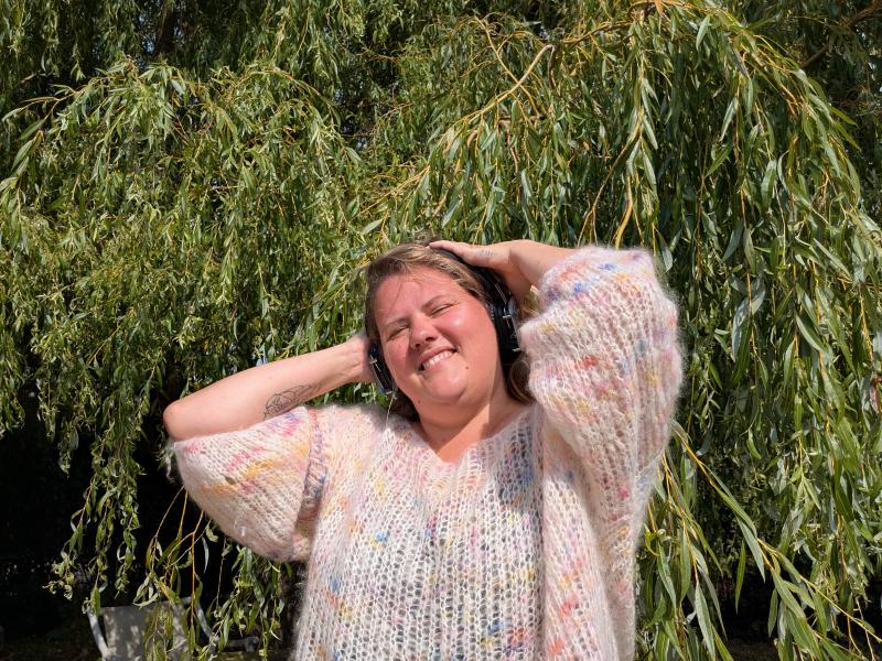 Billedet viser en smilende Kathrine Levald, der groover foran et træ