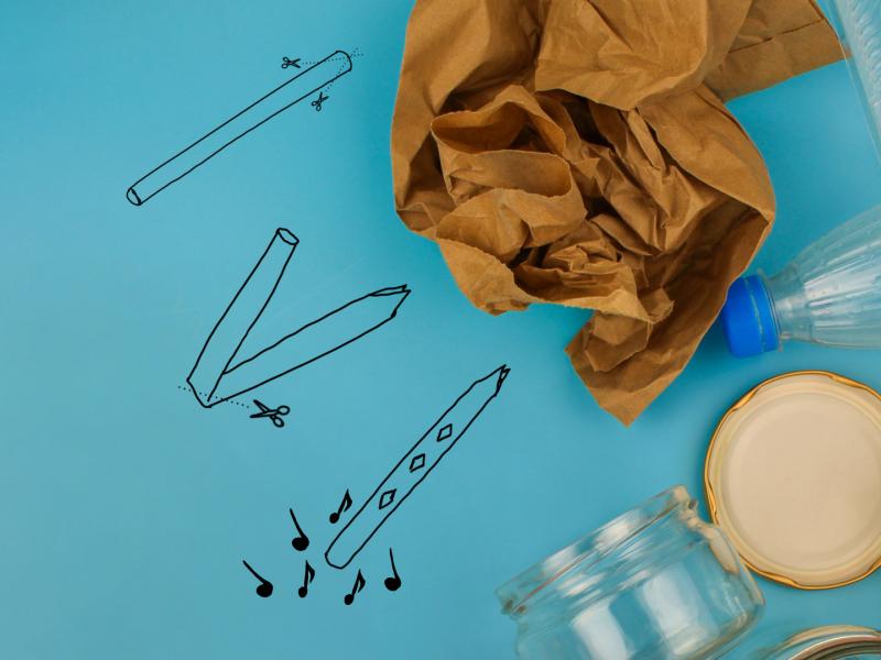 Billedet viser nogle tegnede instrumenter på et stykke papir med flasker, dåser og lignende ovenpå