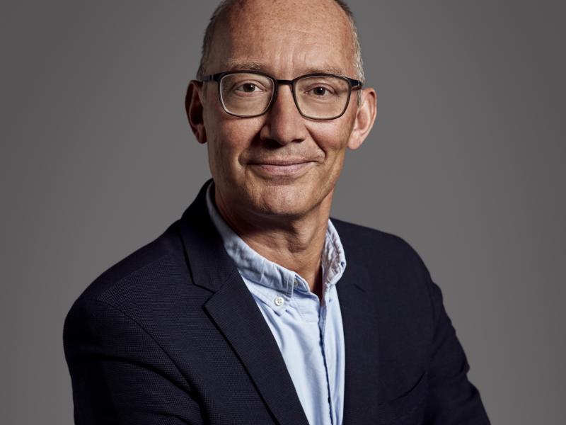 Fotoet viser Niels Krause-Kjær med armene over kors og et venligt smil rettet mod beskueren