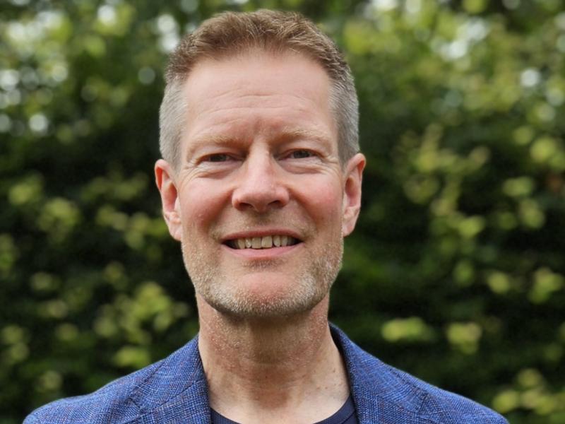 Billedet er et foto af en smilende Claus Thornby Larsen iført blåt tøj med EU-stjerner