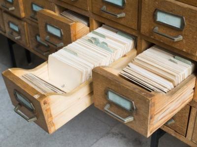 Billedet viser en række gamle arkivskuffer, hvoraf to er åbne