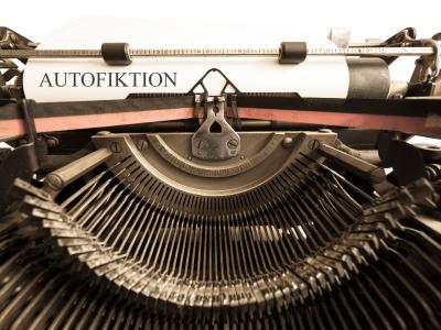 Billedet er et supernærbillede af en gammeldags skrivemaskine, hvor teksten på papiret lyder: Autofiktion