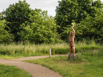 Billedet viser en sti, der forsvinder mellem træer og buske
