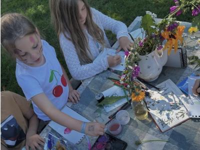 Fotoet viser to børn, der er fordybet i at male planter