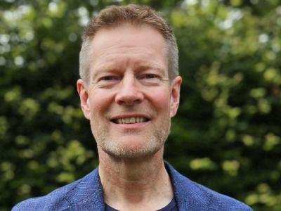Billedet er et foto af en smilende Claus Thornby Larsen iført blåt tøj med EU-stjerner