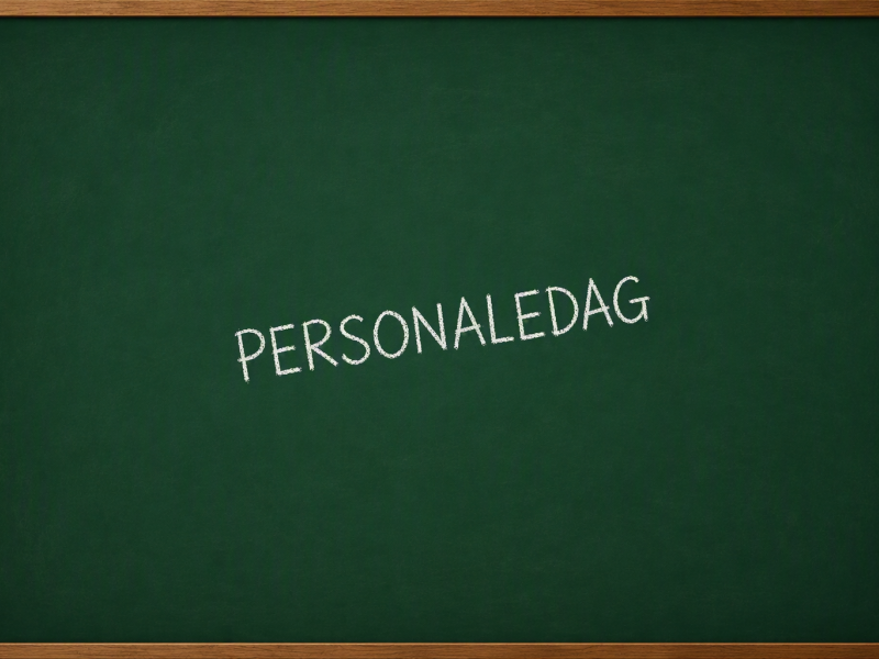 Billedet viser en grøn tavle, hvorpå der er skrevet Personaledag med kridt