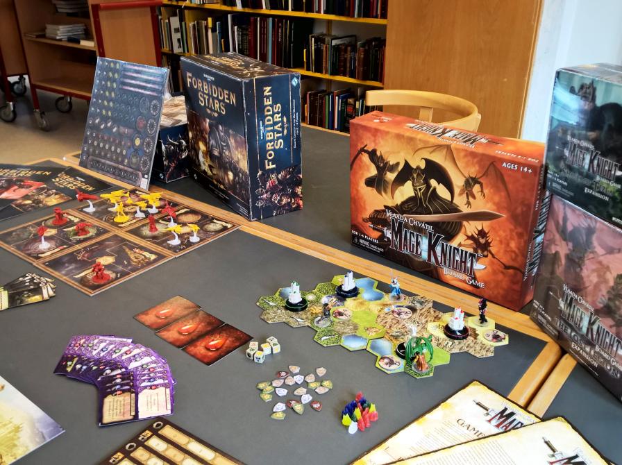 Billedet viser et bord fyldt med forskellige brætspil