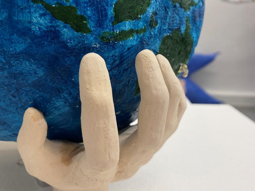 Kunst fra Børnenes Udstilling som forestiller en hånd, der holder Jorden