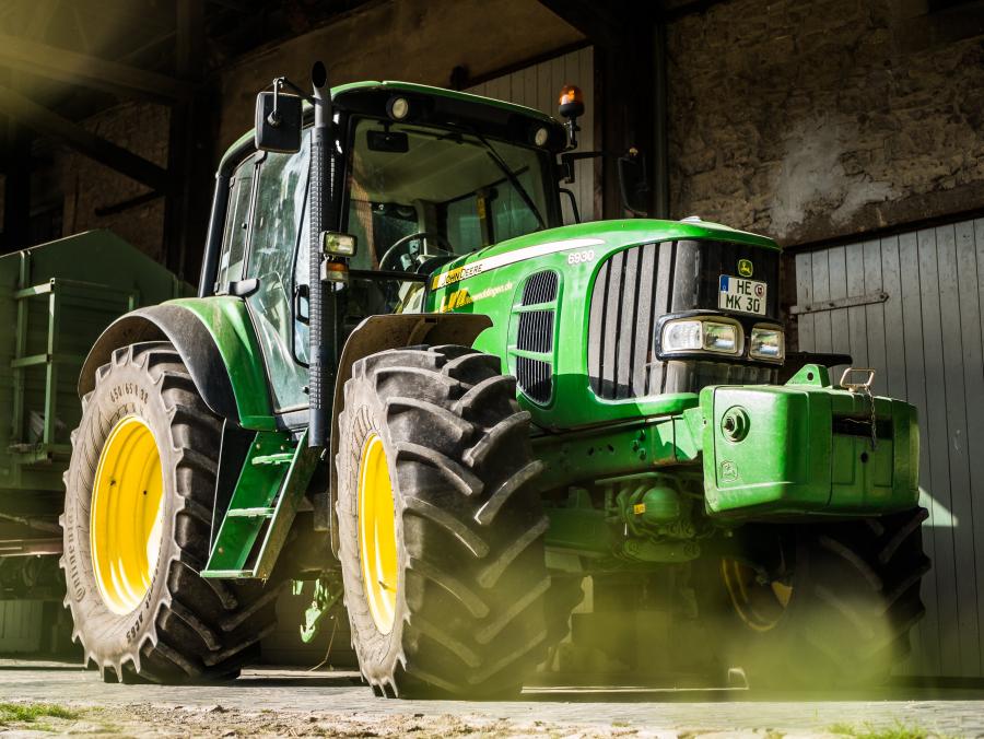 Billedet forestiller en stor, grøn traktor.