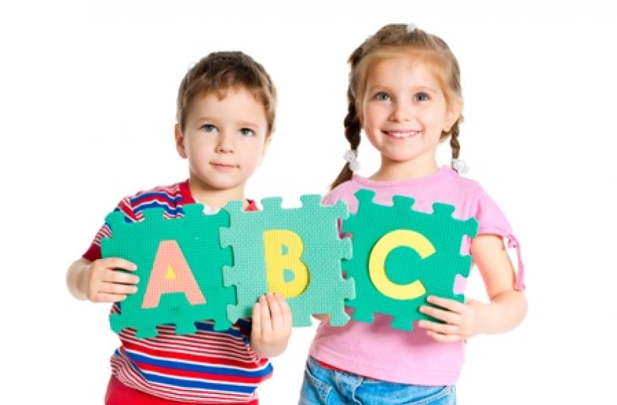 Billede af to børn der holder bogstaver i hænderne.